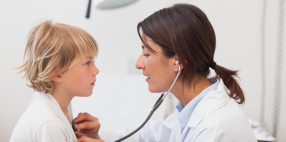 Gutt som blir lyttet på med stetoskop hos legen
